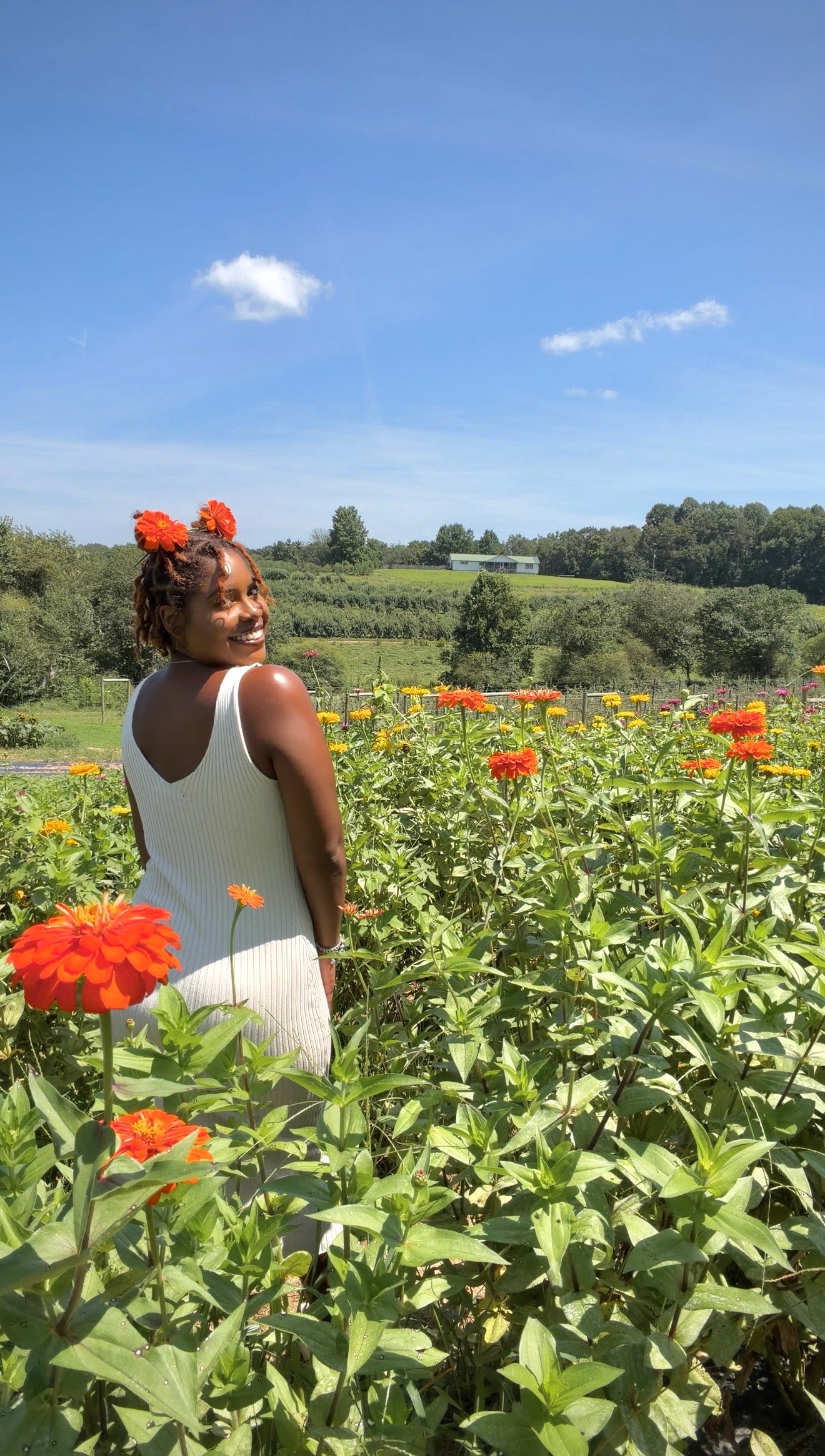 Jess standing peacefully in a field of flowers