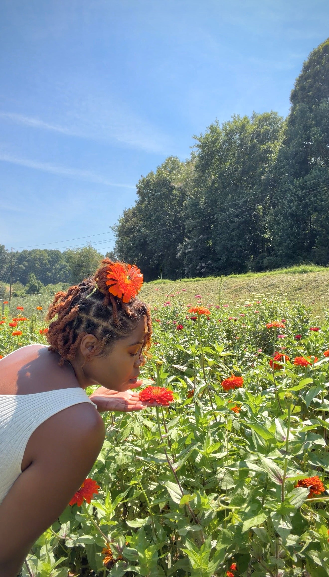 Jess pausing to enjoy an orange flower